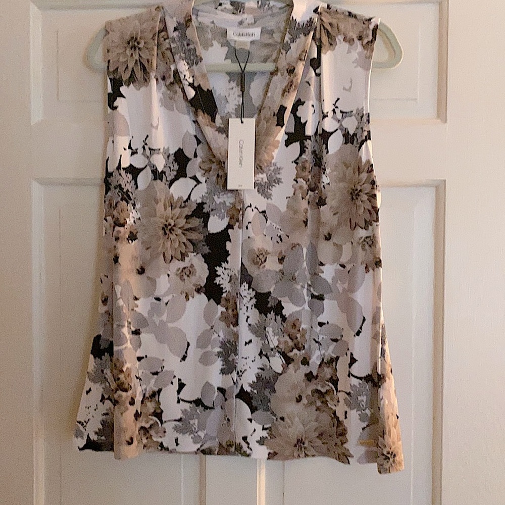 A stylish staple with this sleeveless top. Gathered fabric around the neckline.